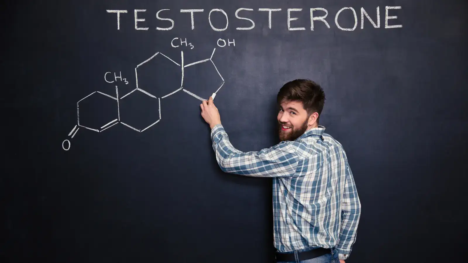 A man at a blackboard drawing the chemical structure of testosterone