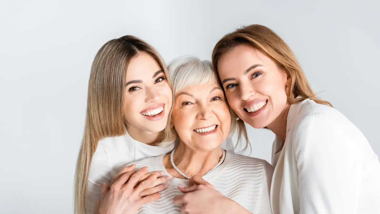 Three generations of women standing together with their arms around each other