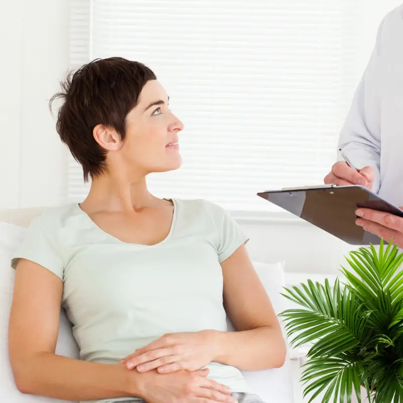 Female patient listening attentively during a naturopathic consultation with a practitioner taking notes